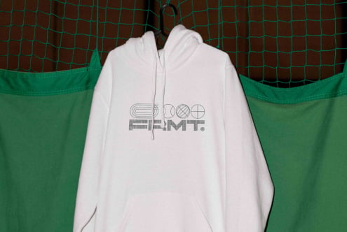 White hoodie on hanger with geometric logo print against green mesh backdrop