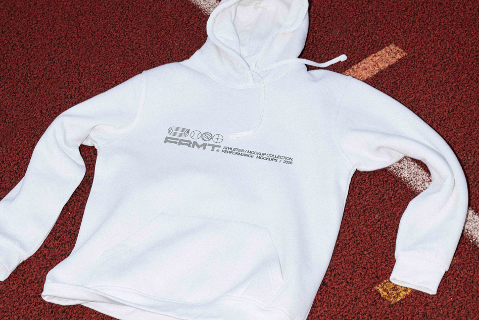 Cream hoodie laid out showing small Athlete chest graphic on red track