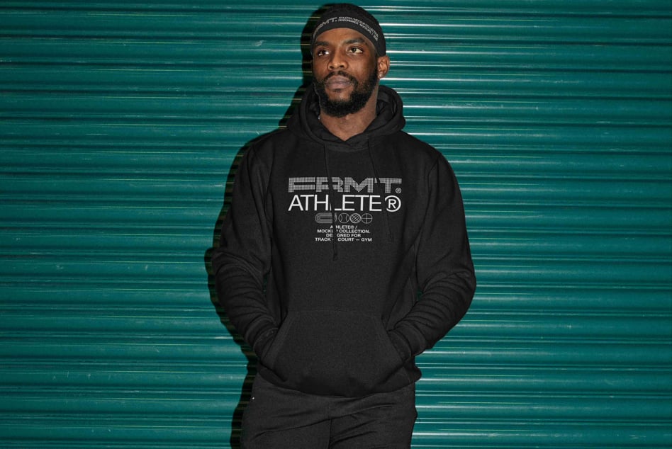 Man wearing black hoodie with geometric Athlete logo against teal metal backdrop