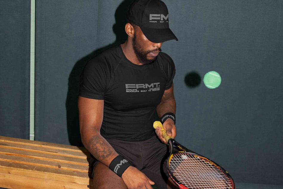 Tennis player in black branded tee on bench with racket looking away