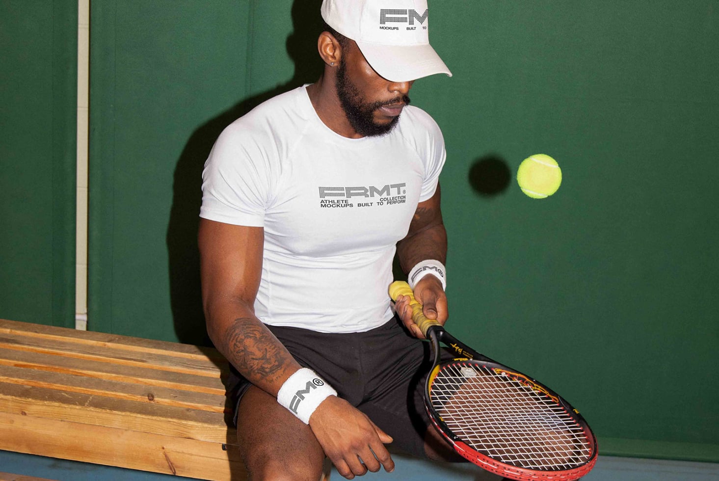 Tennis player in white branded tee on bench holding racket