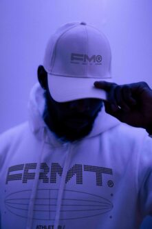 White hoodie hooded sweatshirt with FRMT branding against purple neon lighting
