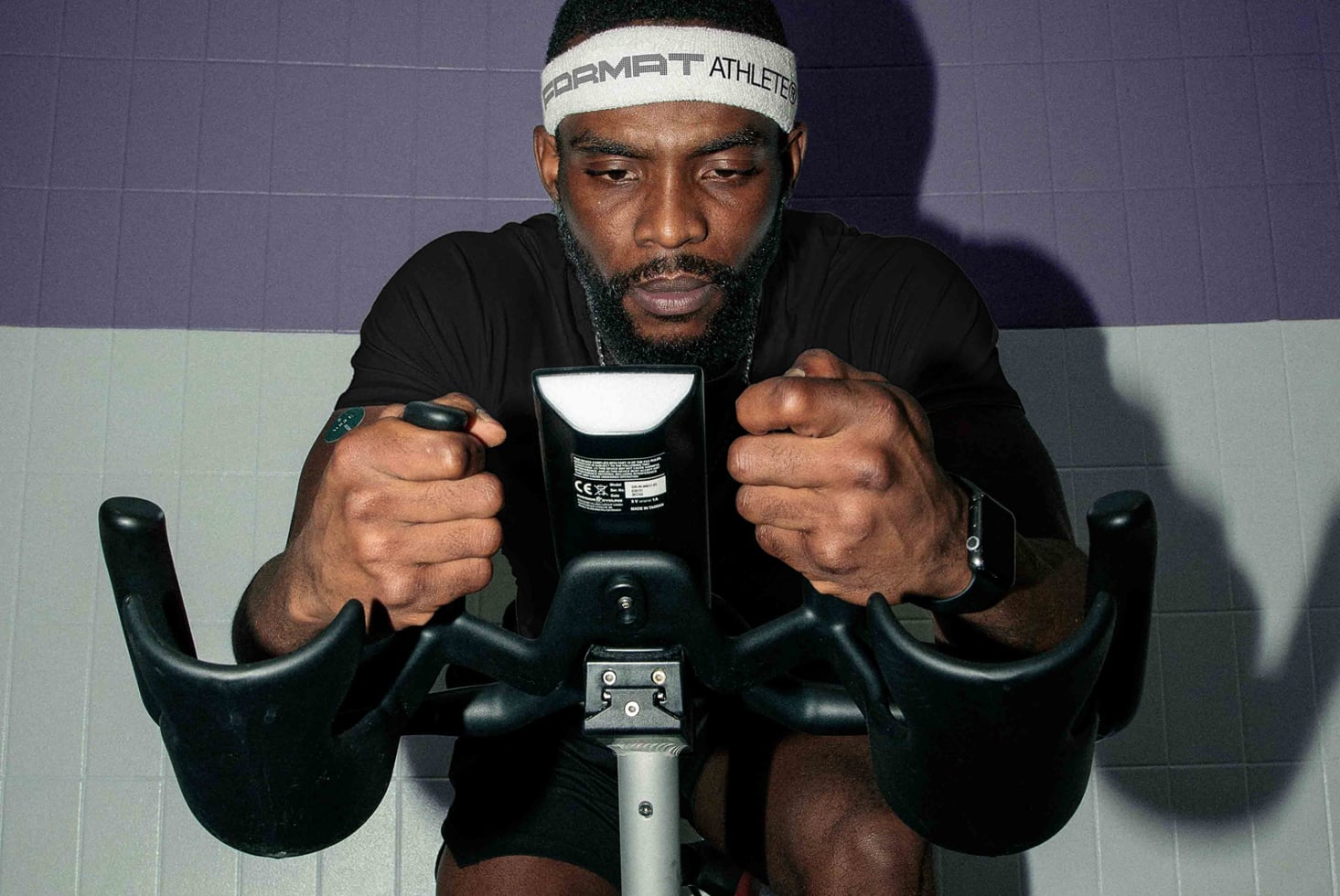 Athlete gripping bike handlebars during intense spin workout