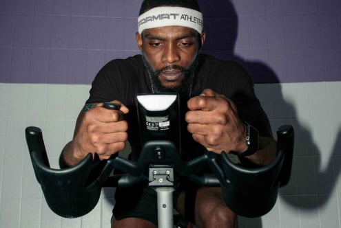 Athlete gripping bike handlebars during intense spin workout