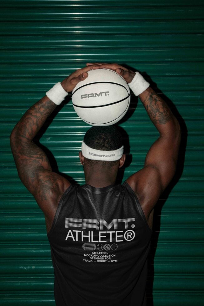 Athlete holding white basketball with PRMT branding overhead against teal corrugated wall