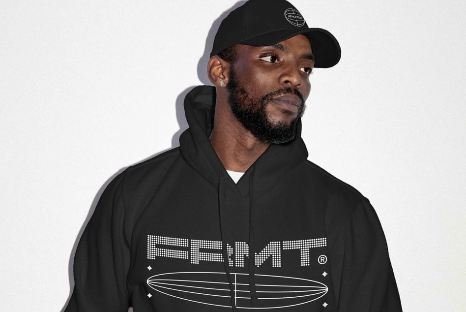 Guy in black hoodie with surfboard logo design mockup on white backdrop