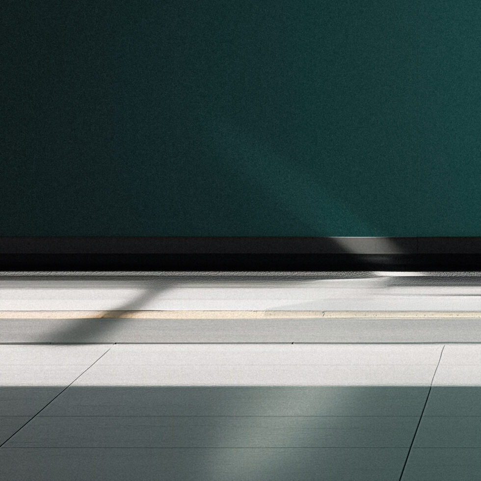 Minimalist interior with teal wall, white trim, concrete floor, natural light shadow