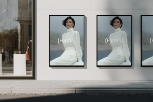 Storefront window displaying framed portrait photography mockups with black frames