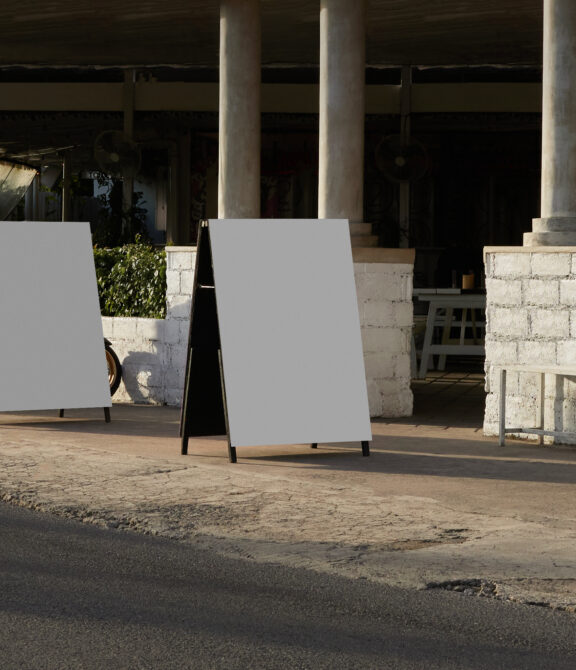 Blank A-frame sandwich board sign on concrete in brutalist architectural setting