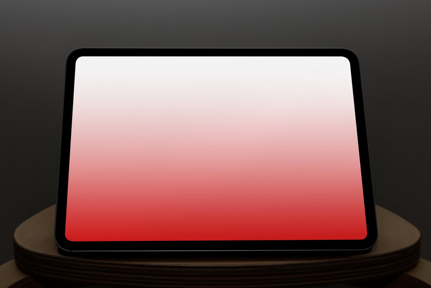 Tablet on stand displaying red gradient, landscape position