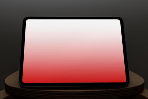 Tablet on stand displaying red gradient, landscape position