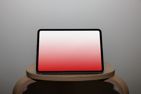 Tablet on wooden stand with red gradient screen, portrait orientation