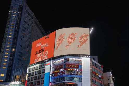 Night city view showing orange text overlay on curved blank billboard, modern skyscraper backdrop
