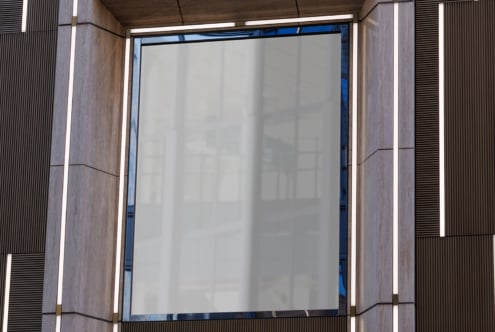 Close-up of empty storefront poster space inside modern concrete entrance with white glow