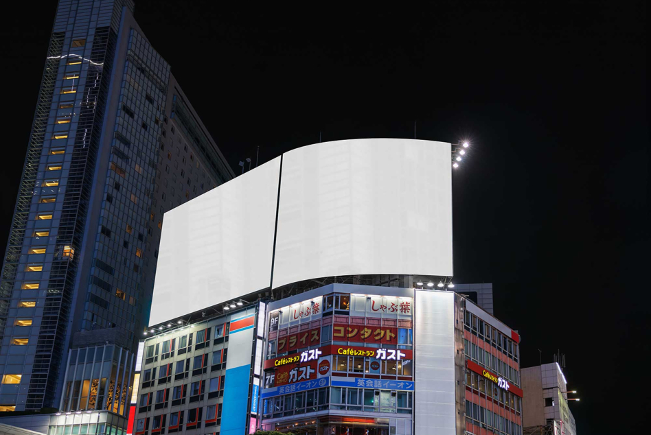 Nighttime cityscape with large blank curved sign above storefronts, bright white display space