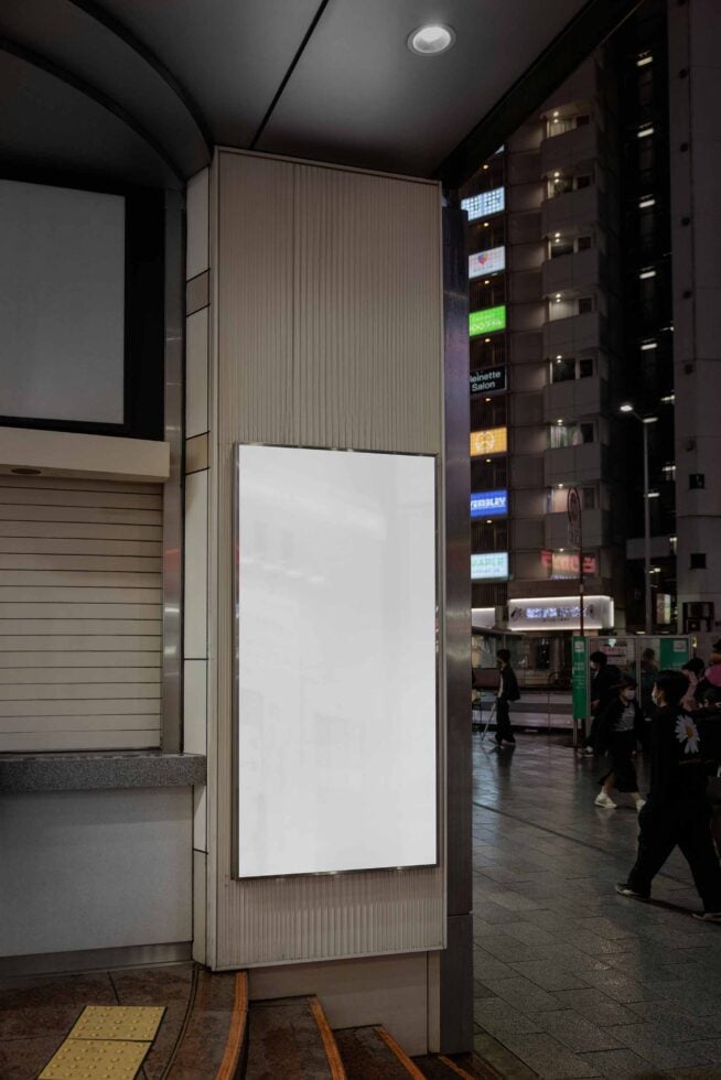 Empty vertical billboard panel on building storefront in crowded downtown area