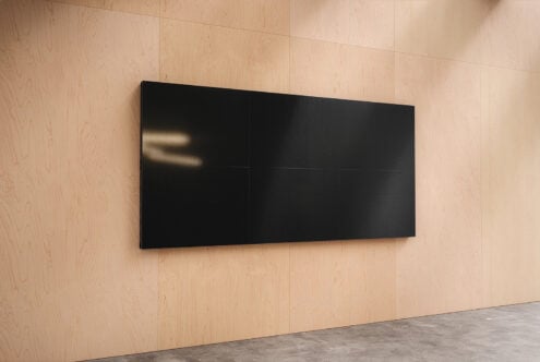Black horizontal screen mockup on wood wall catching afternoon light