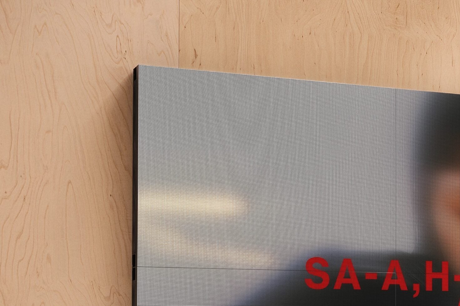 Mounted screen display with pixelated gradient on light plywood wall