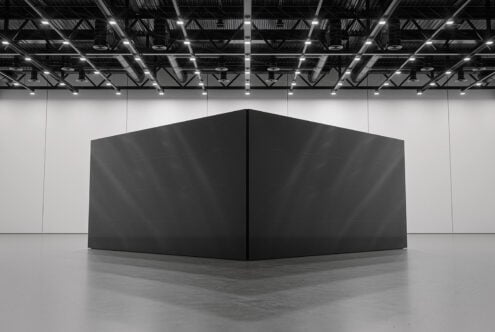 Black box structure in empty gallery space with steel ceiling