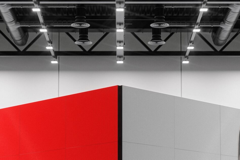 Industrial warehouse with red wall meeting gray wall under lights