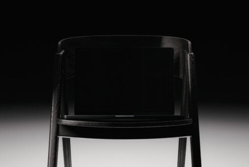 Minimalist black wood chair mockup with blank screen on dark background