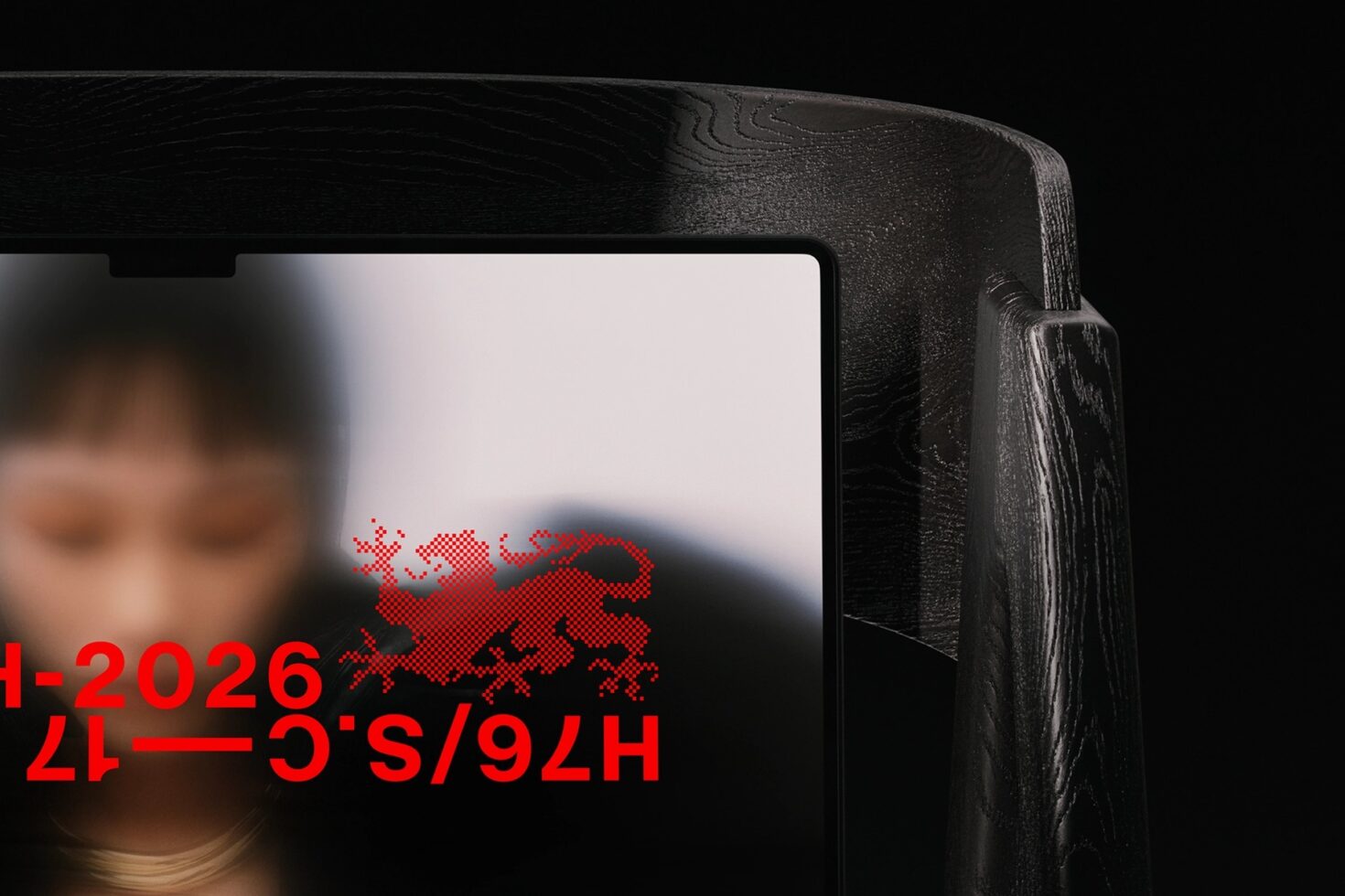 Black wooden device frame displaying red pixelated dragon with date
