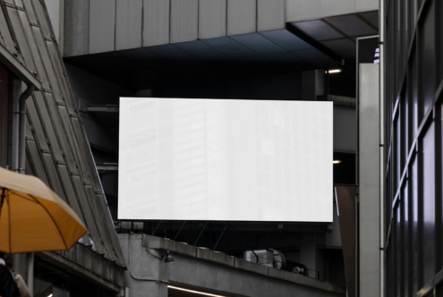 Empty rectangular screen on concrete building facade between metal railings