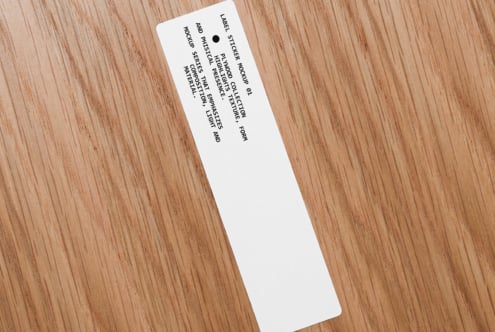 White narrow label sticker on wood angled showing full text layout design