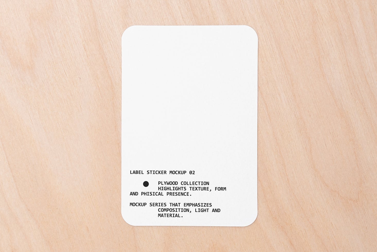 White rounded square sticker on light wood with text centered bottom