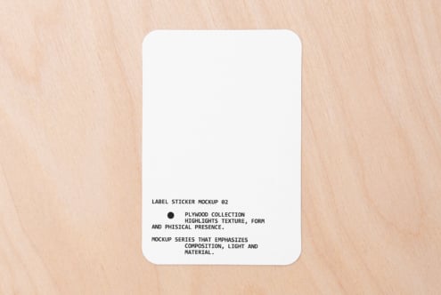 White rounded square sticker on light wood with text centered bottom