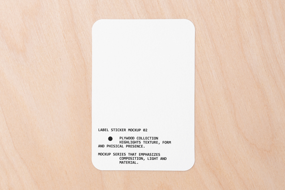 White rounded square sticker on light wood with text centered bottom