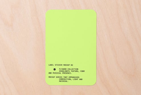Neon yellow rounded square sticker on light wood with text centered bottom