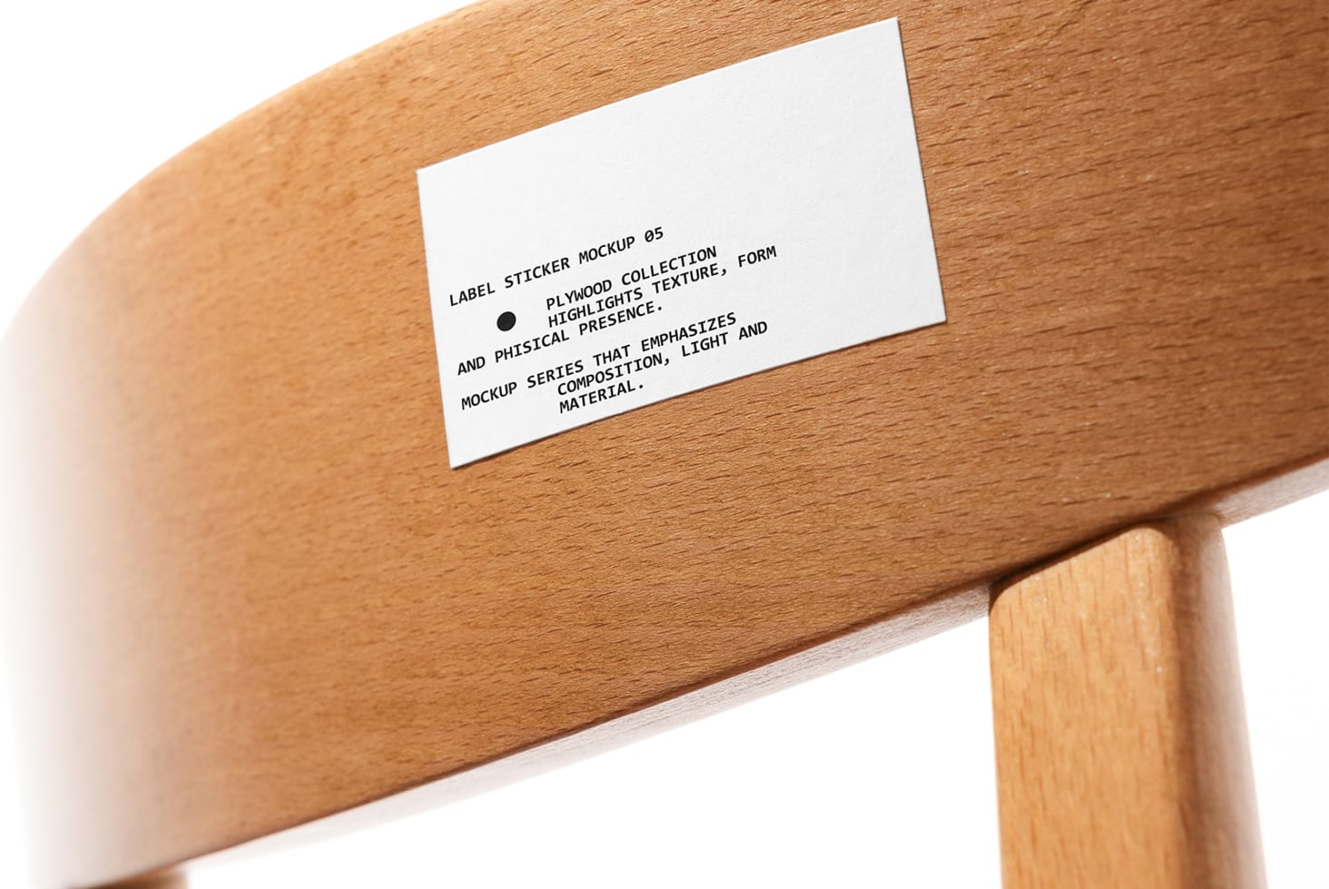 White label sticker on wooden chair arm with black text about plywood collection