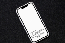iPhone mockup angled on dark speckled background with blank white screen