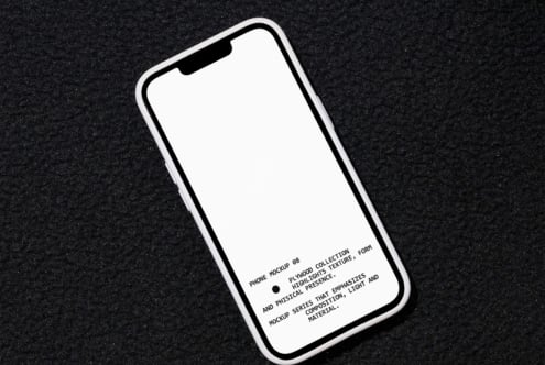 iPhone mockup angled on dark speckled background with blank white screen