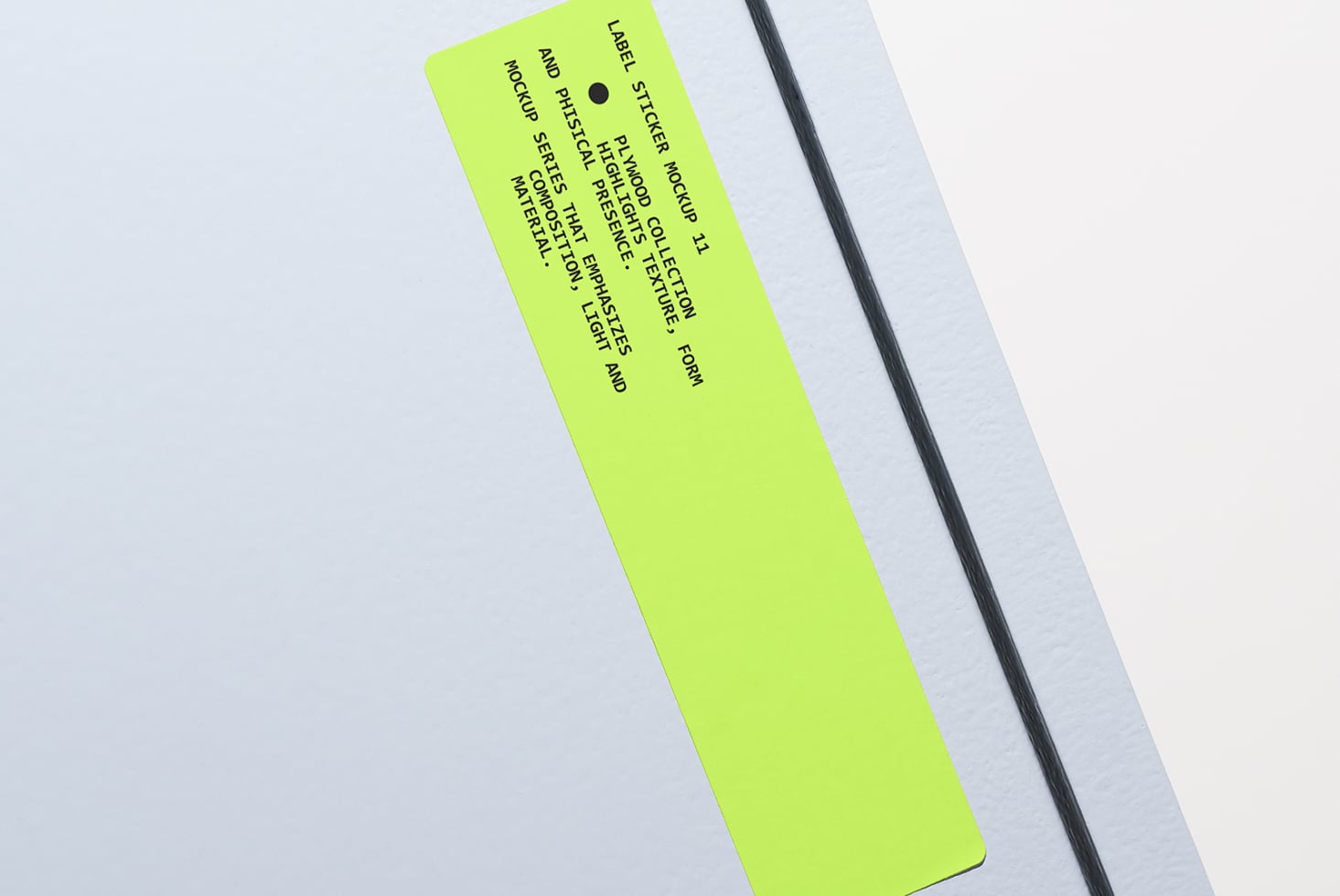 Bright lime sticker label at angle on soft gray surface mockup