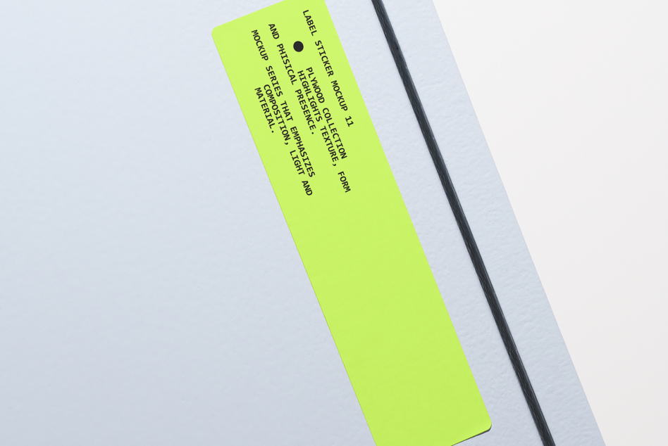 Bright lime sticker label at angle on soft gray surface mockup