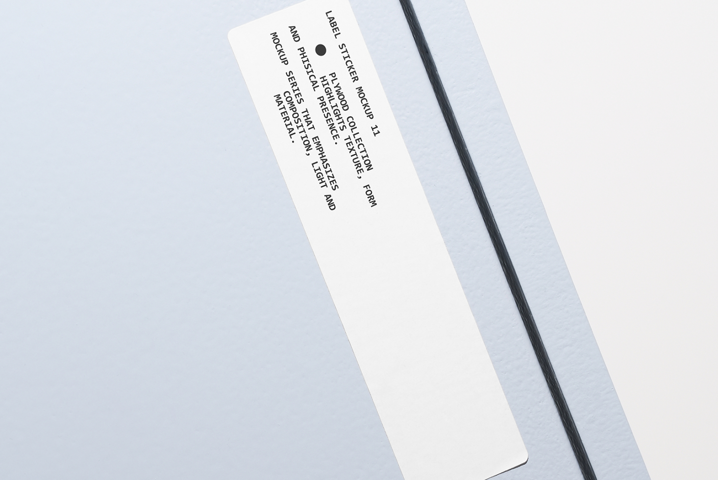 Cream colored rectangular sticker label tilted on plain gray backdrop