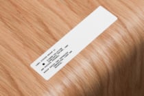 White rectangular label sticker mockup on natural wood surface