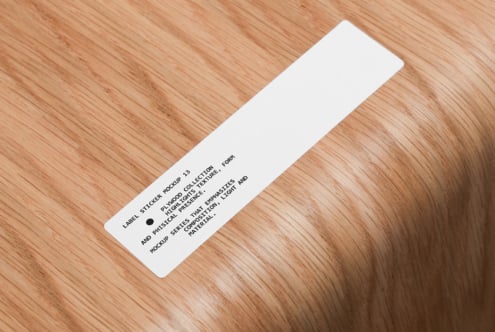 White rectangular label sticker mockup on natural wood surface
