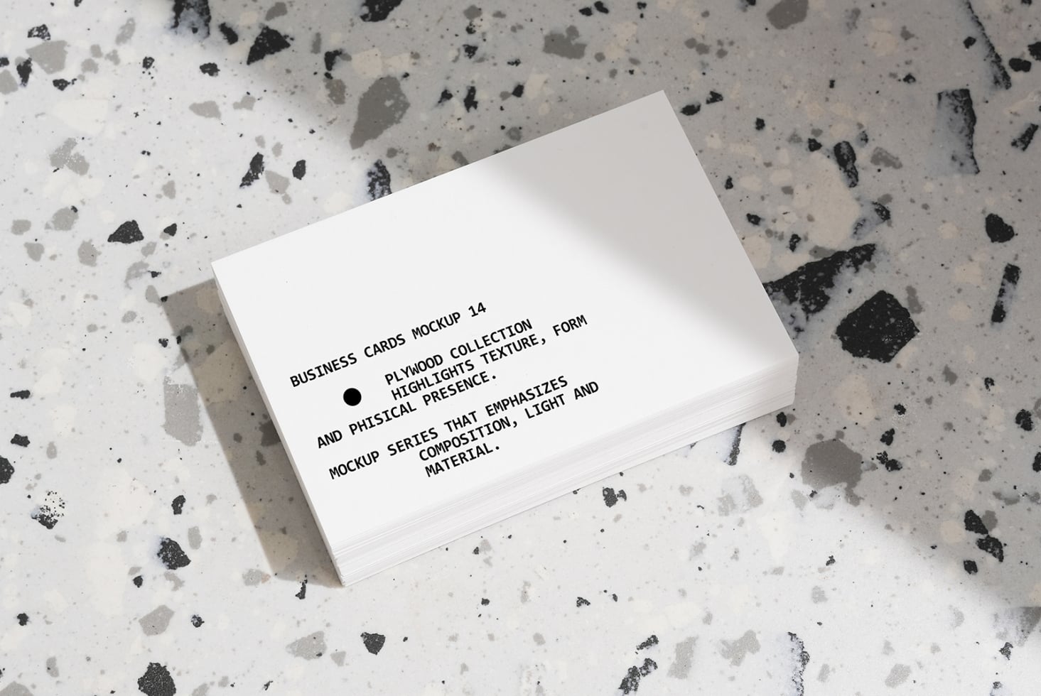 Stacked white business cards on terrazzo background with shadow detail