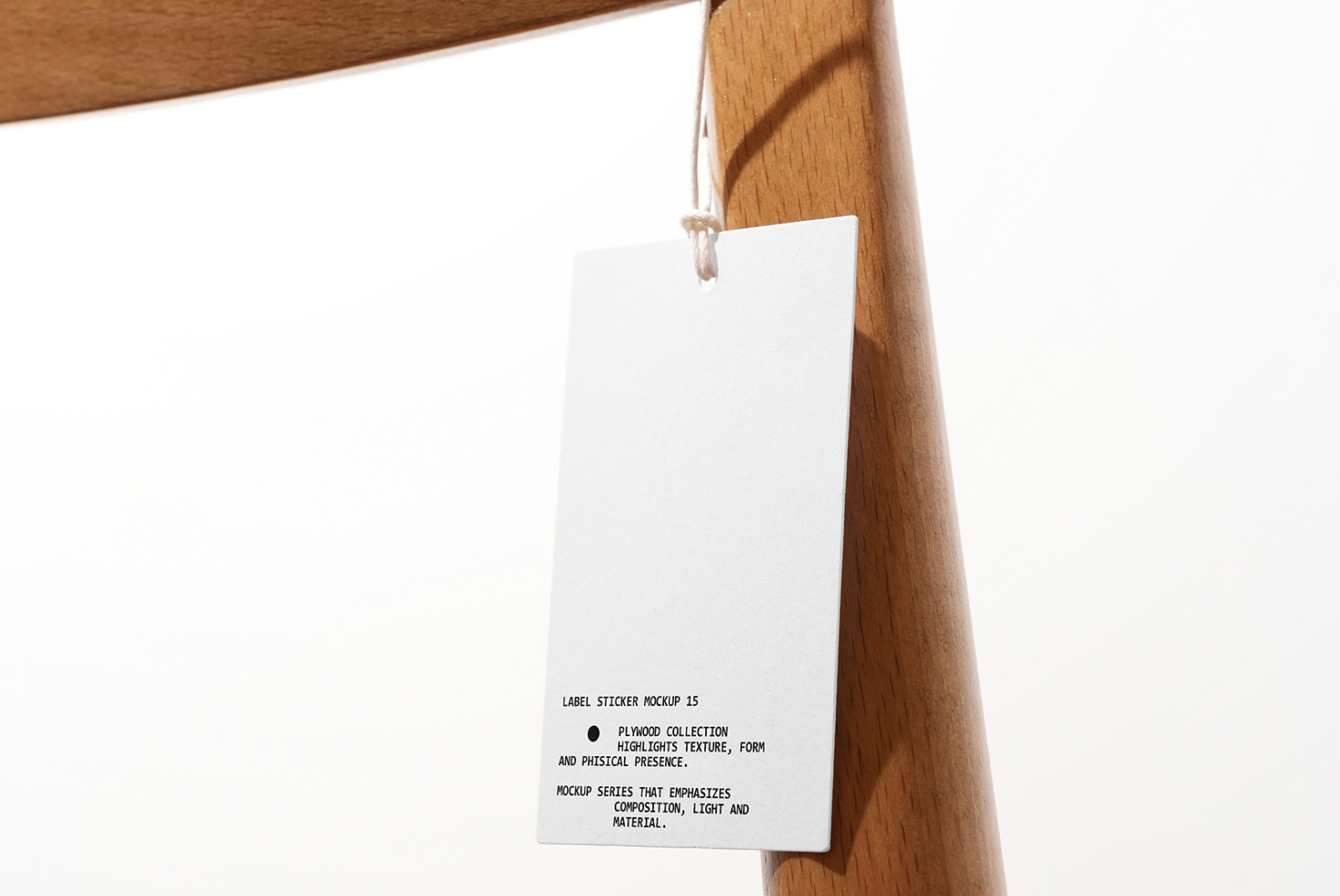 White rectangular hang tag hanging from twine on wooden rack