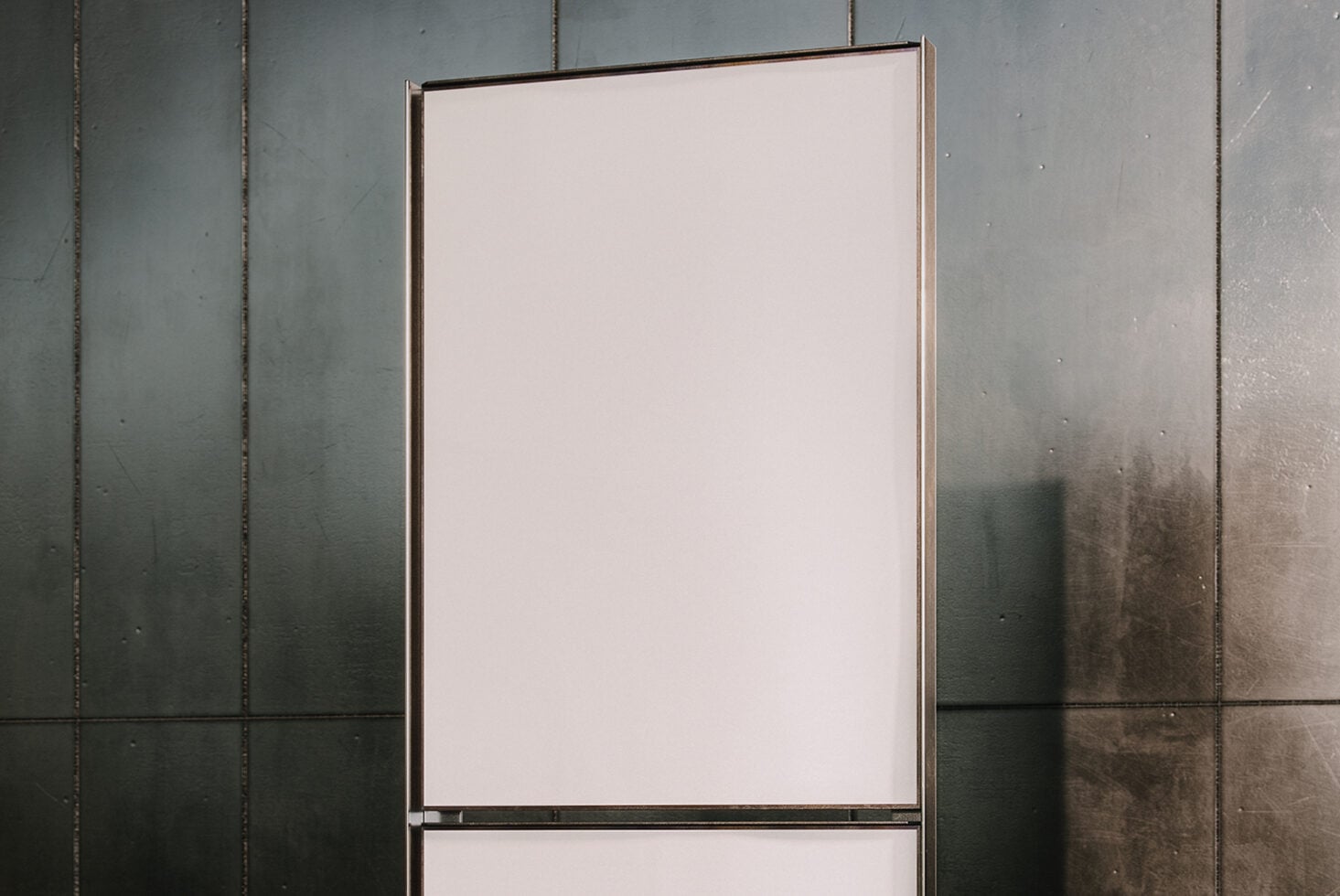 Blank cream colored poster mockup against weathered metal wall panels