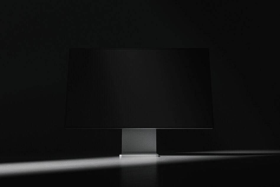 Dark minimalist monitor mockup centered on desk against black background