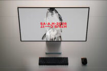 Desktop monitor with blank black screen centered on neutral desk