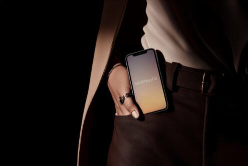 Woman in brown leather bag holding phone with soft yellow-purple gradient
