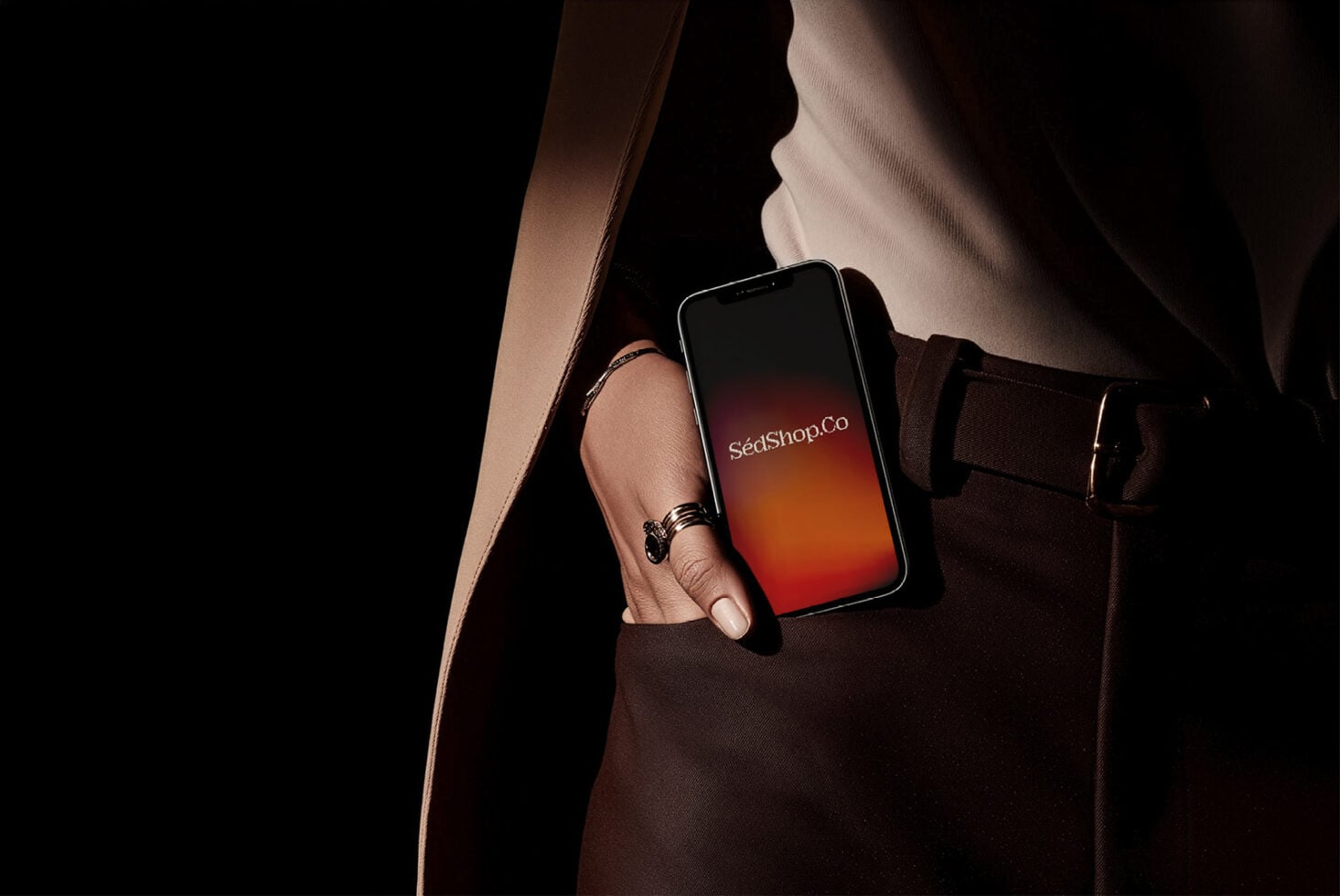 Woman in brown leather bag holding phone with red-orange gradient screen