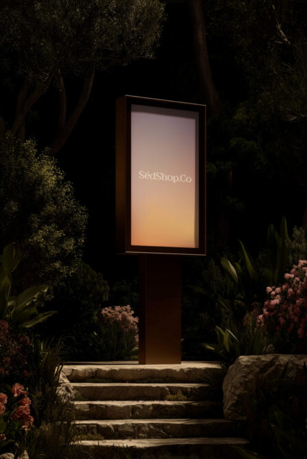 Vertical lit panel in nighttime garden with warm glow showing SédShop.Co branding