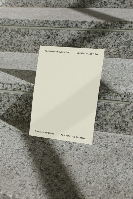 Off white blank card propped on terrazzo floor with subtle branding at top