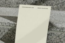 Cream card tilted showing top header text on granite background with natural light